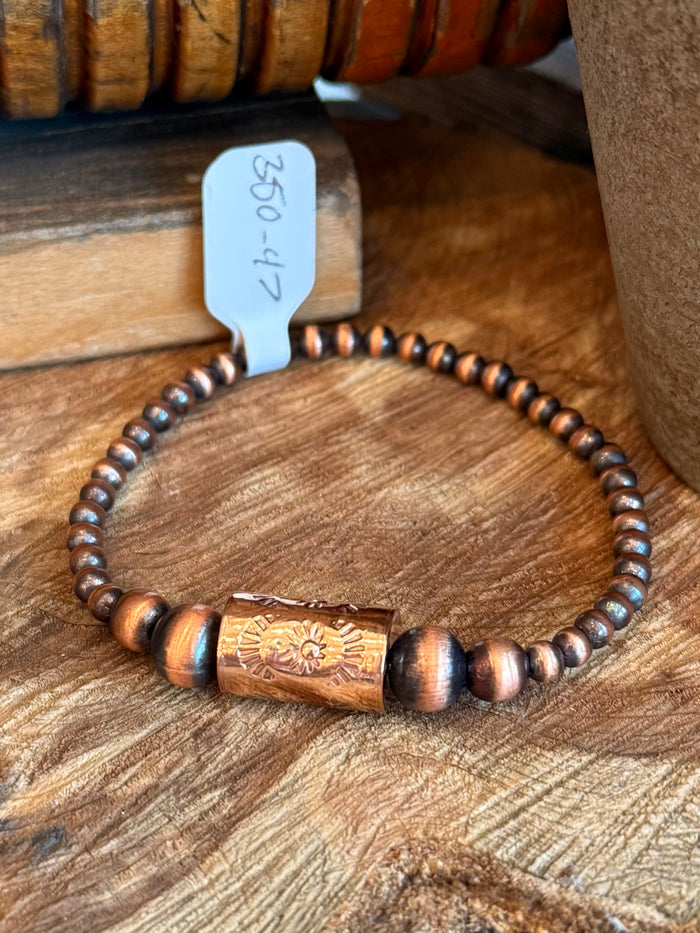 Copper centerpiece barrel bead on dark bead stretch bracelet