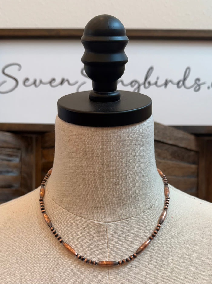 18-inch copper torpedo bead necklace with dark bead strands on mannequin