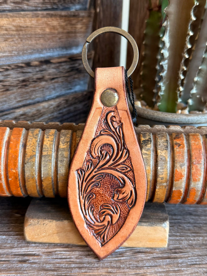 Brown leather keychain with detailed floral tooling, round rivet, and key ring
