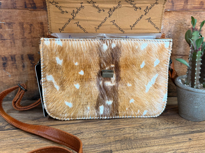 Speckled cowhide flap crossbody purse with white stitching and black buckle center