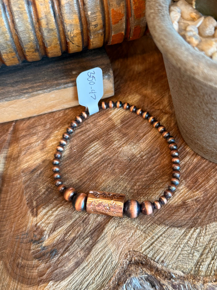 Copper barrel bead stretch bracelet with engraved center and dark beads