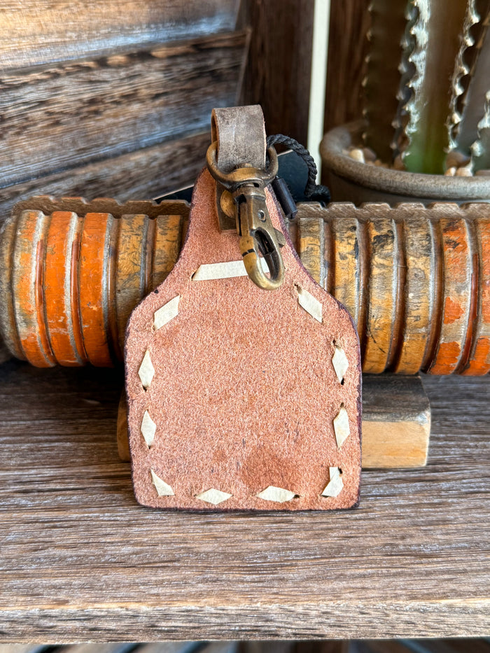 Orange leather cactus keychain back with metal clip and stitched cutout edges.