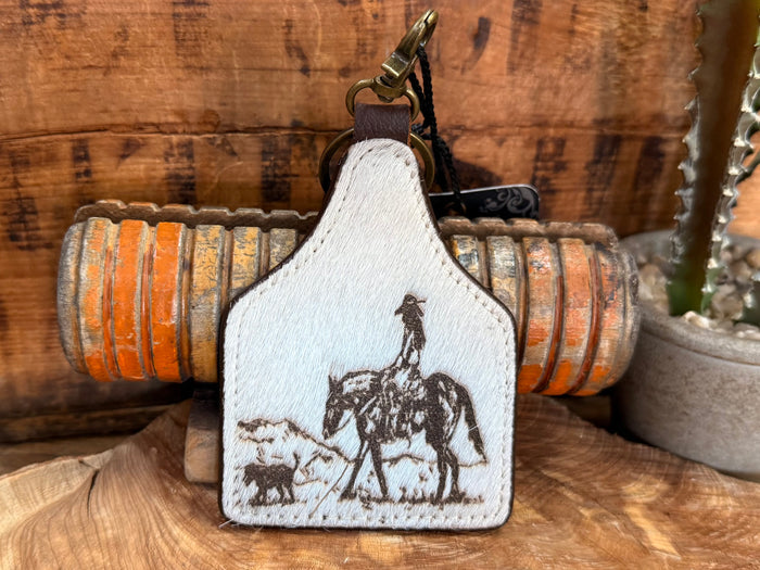 Cowgirl dog hair-on key fob, close view of white patch with horse and dog silhouettes