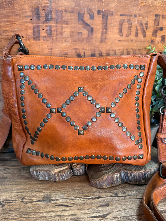 Studded cognac leather flap crossbody purse, front with heart and arrow stud design