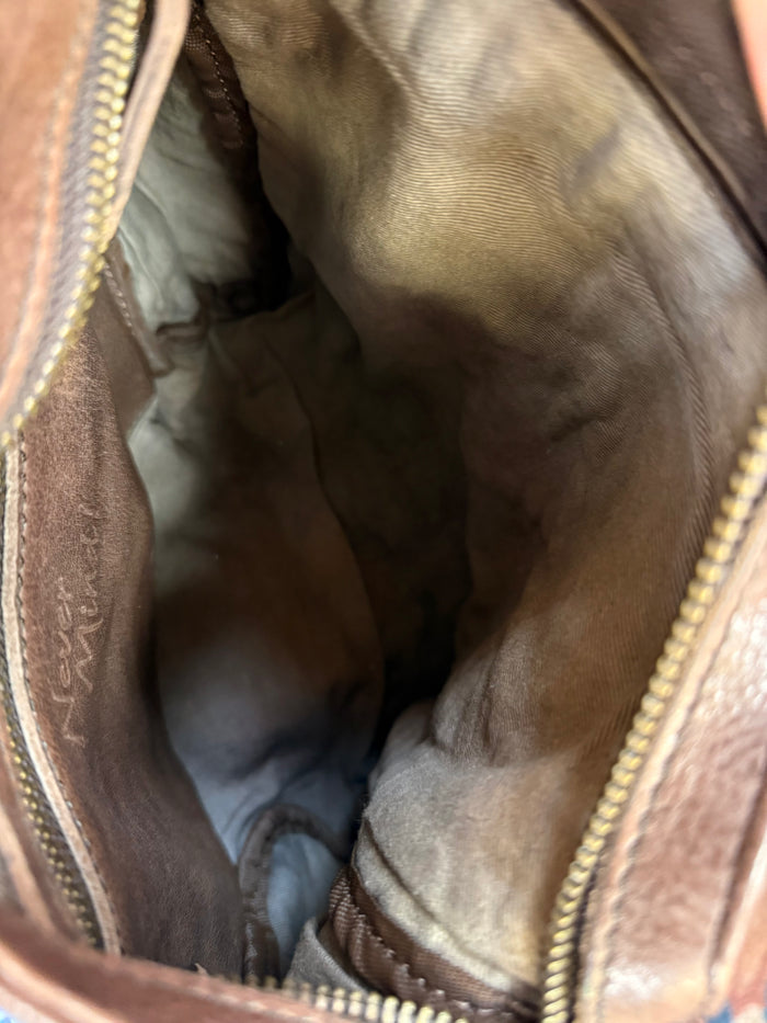 Inside view of chocolate brown zip-top crossbody purse with fabric lining