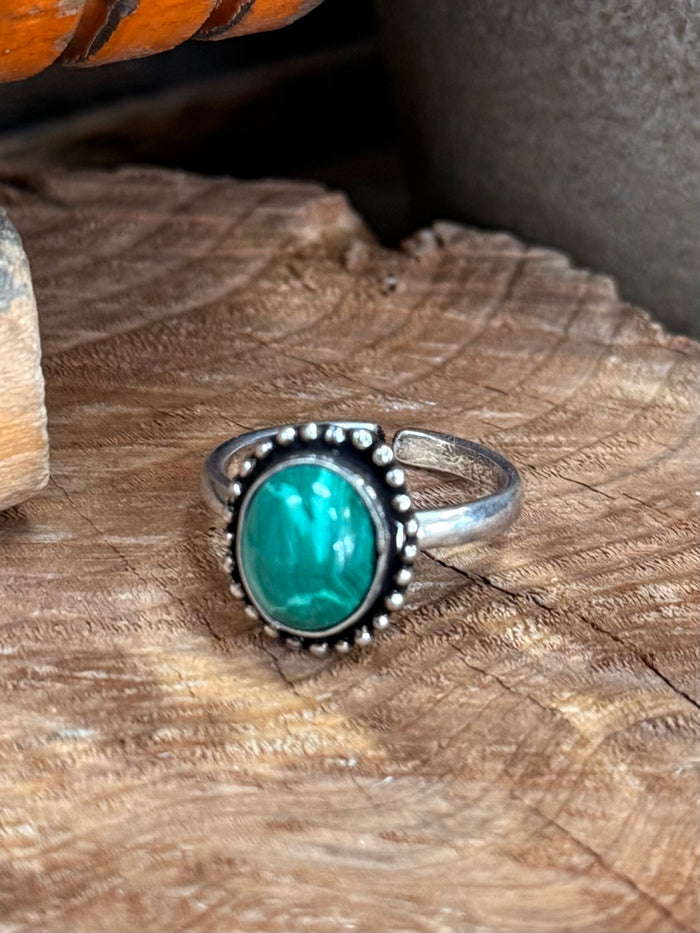 Silver-toned adjustable ring with large round turquoise stone and small bead halo details