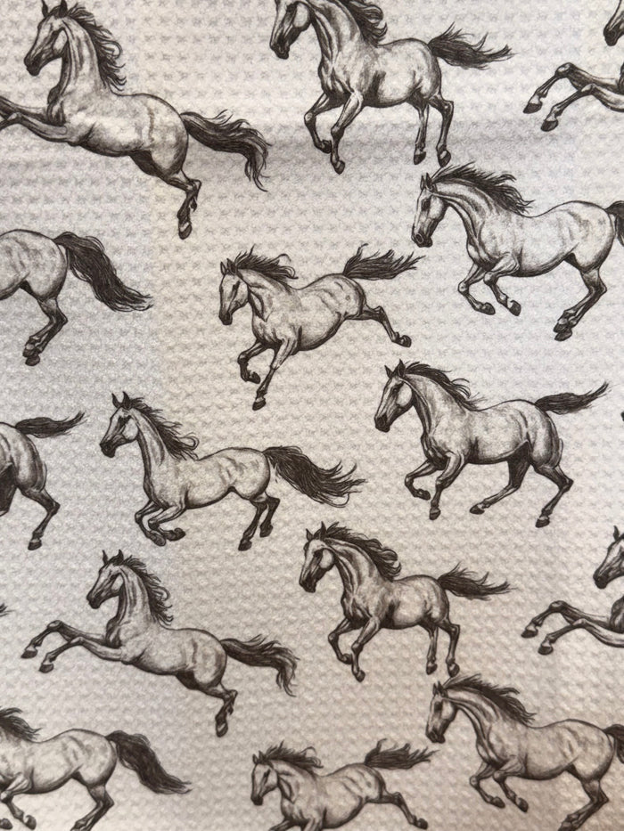 Close-up of running horses towel pattern with textured waffle weave