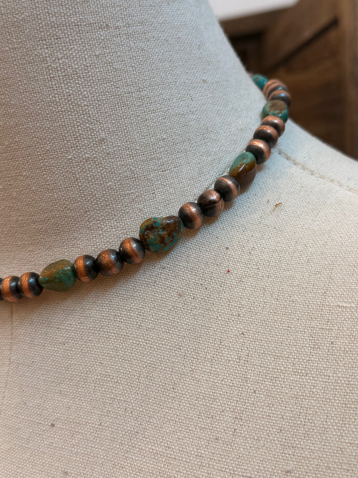 Close-up of turquoise and copper bead necklace strand with round beads