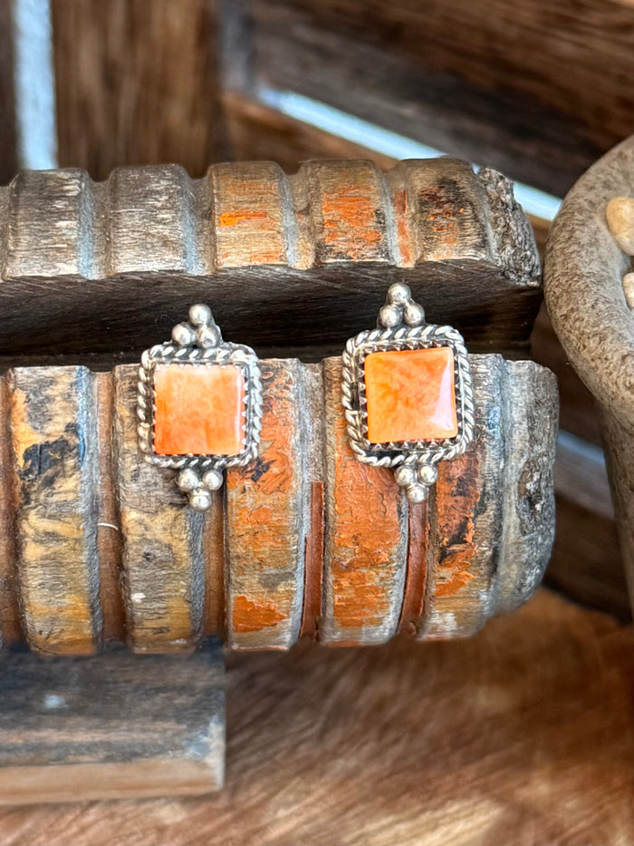Pair of orange spiny square stud earrings in silver-tone bezel settings