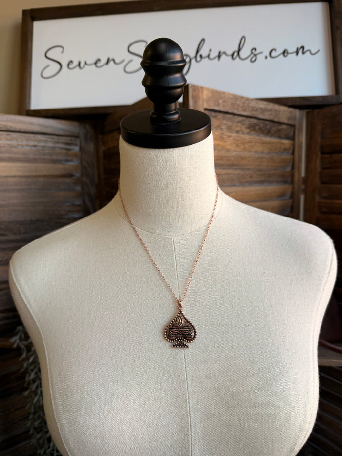 Copper spade pendant necklace with long chain on mannequin