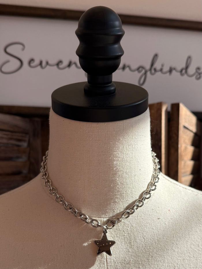 Silver star pendant necklace with dangling star charm and curb chain