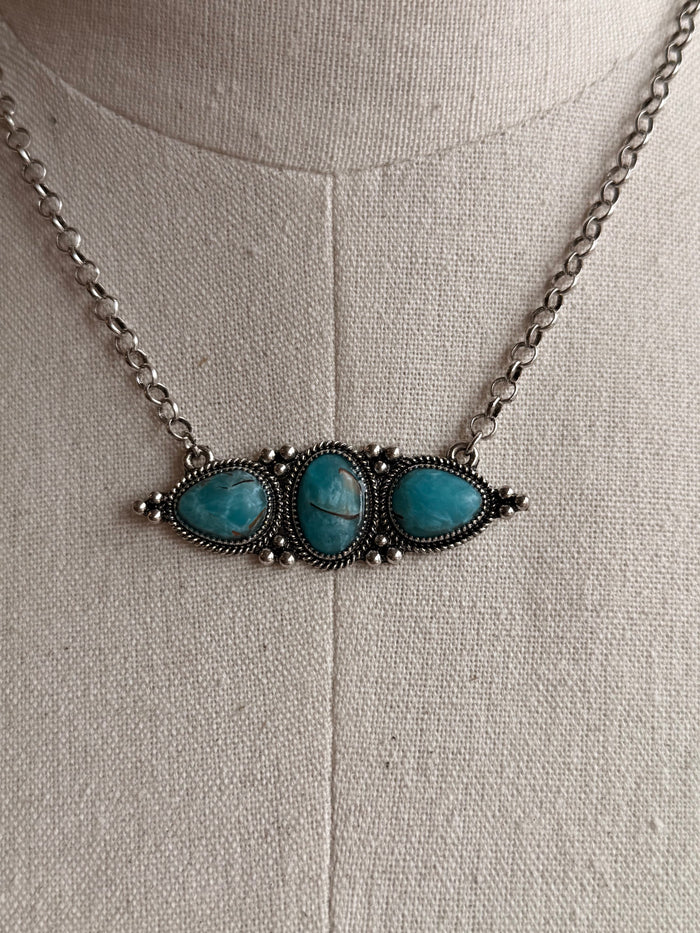 Turquoise oval triple-stone pendant necklace with bead details and silver chain