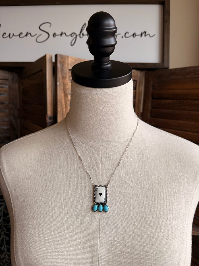 Silver-tone chain necklace with rectangular ace charm and turquoise bead drop