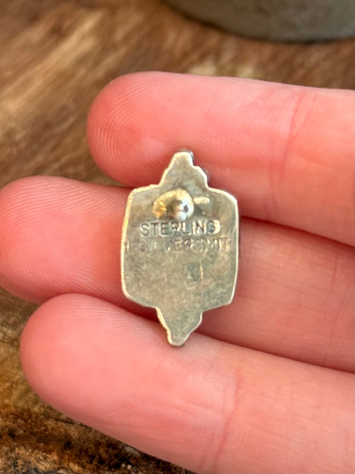 Sterling silver back of a square stud earring stamped STERLING