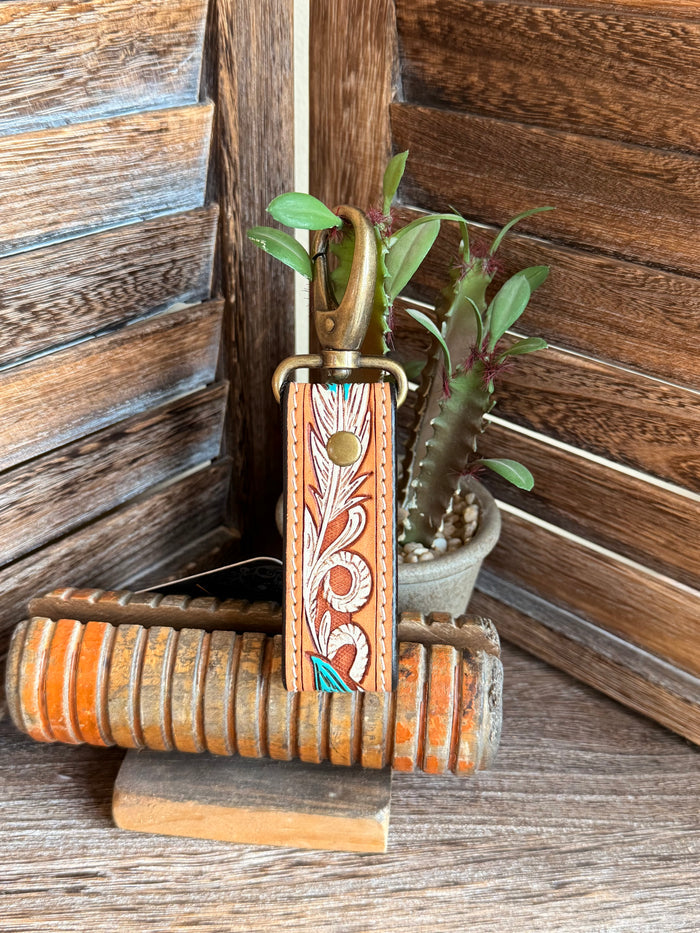Tooled leather keychain with turquoise feather in orange strap and brass key ring