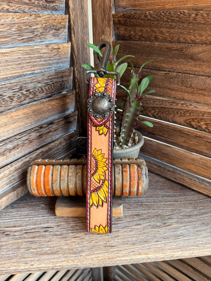 Tooled leather sunflower keychain with orange strap and silver heart clasp, green leaf accents