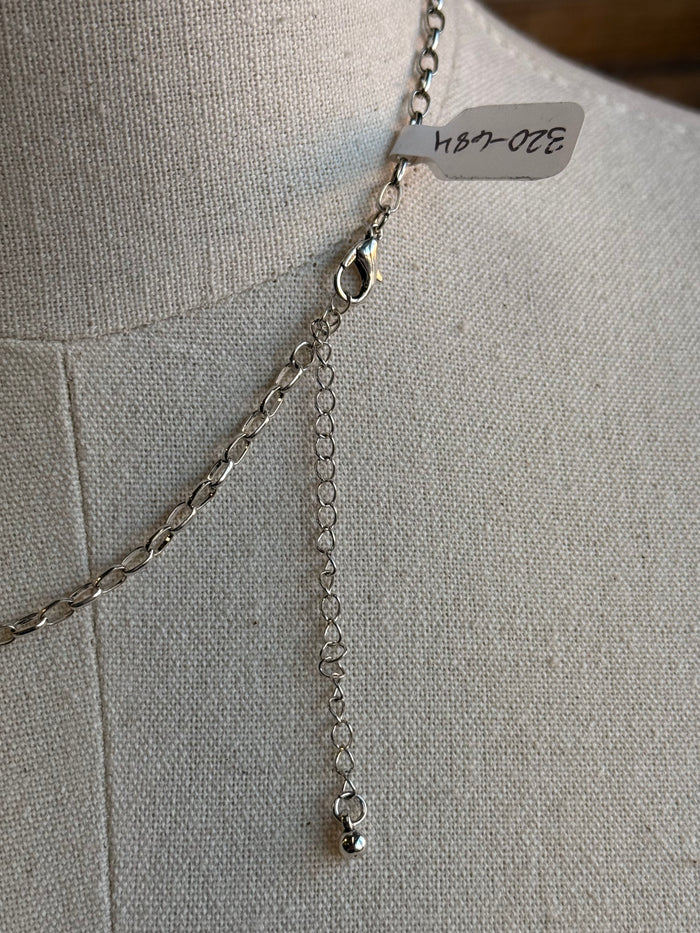 Silver chain necklace with cowboy hat rope pendant and small hanging tag