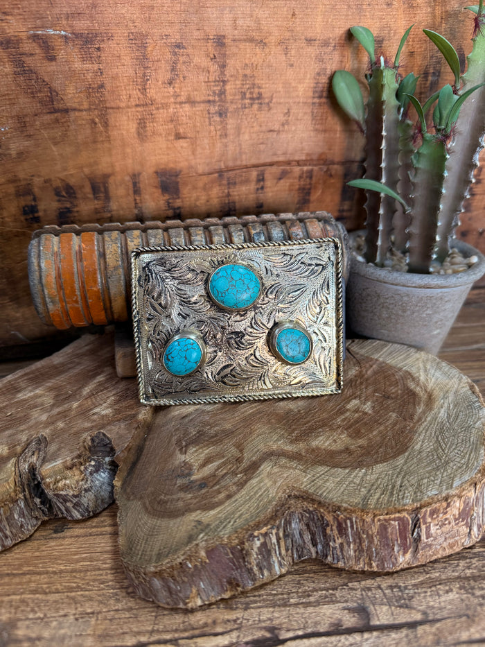 Engraved silver-tone belt buckle with three turquoise inlay stones, rectangular frame