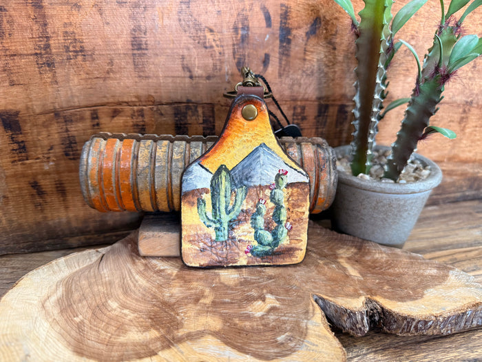 Handpainted cactus leather key fob with yellow-orange top and blue desert scene