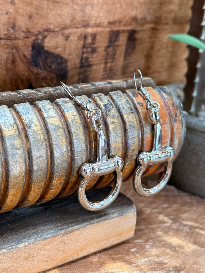 Silver snaffle bit earrings viewed from the side, with hinged ring and hook