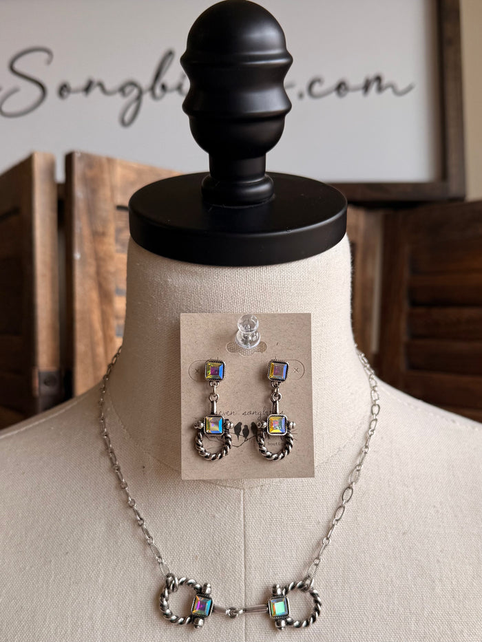 Silver-tone snaffle bit necklace and multicolor charm stud earrings on stand