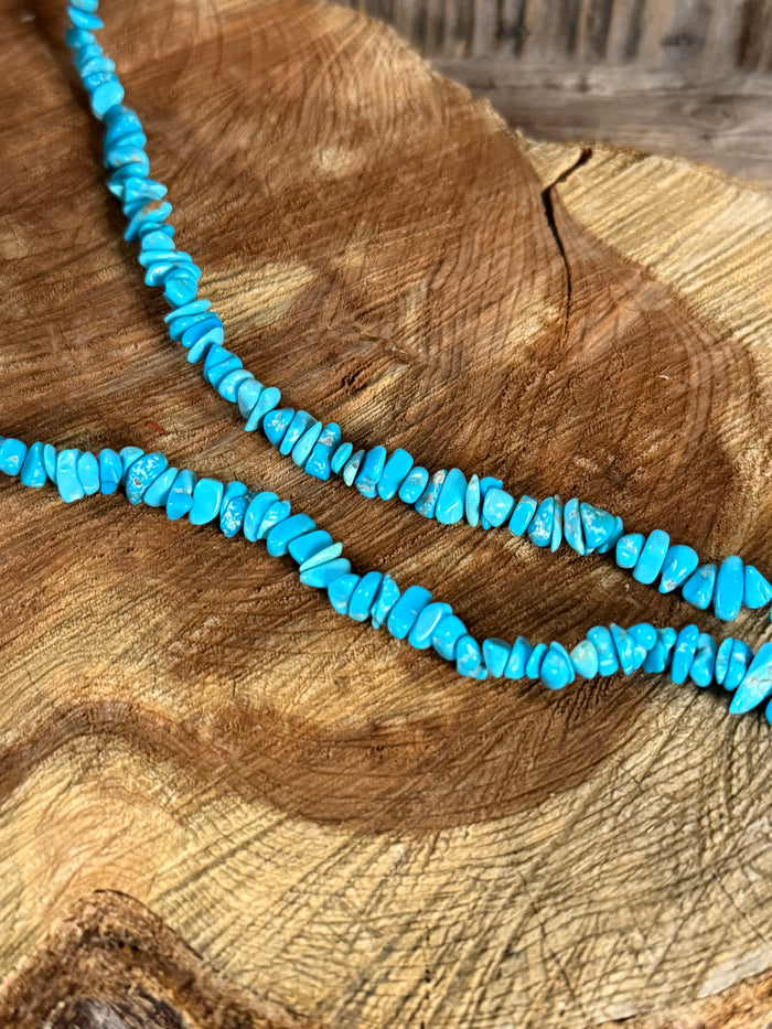 Close-up of turquoise chip bead strand necklace with small irregular beads