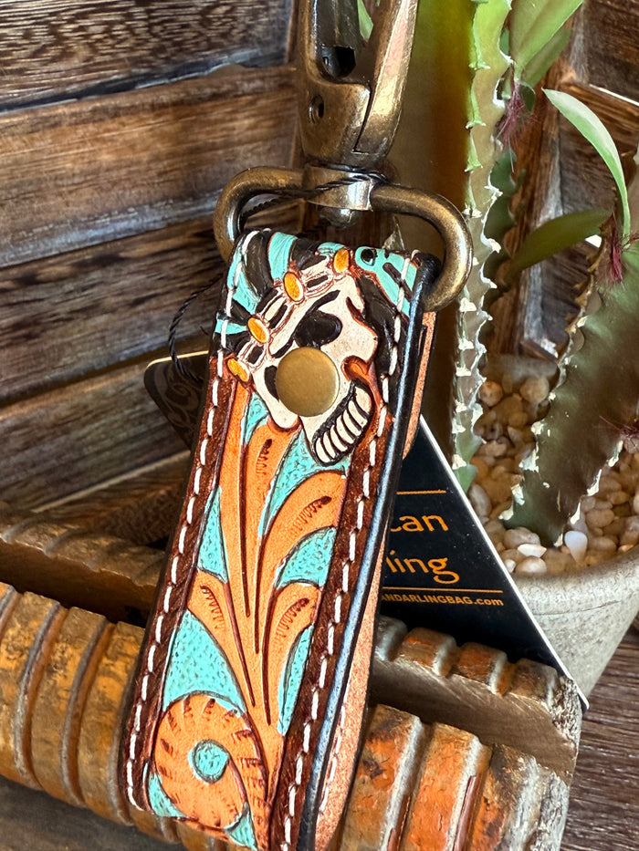 Close-up: turquoise tooled leather keychain strap with brass ring and owl emblem
