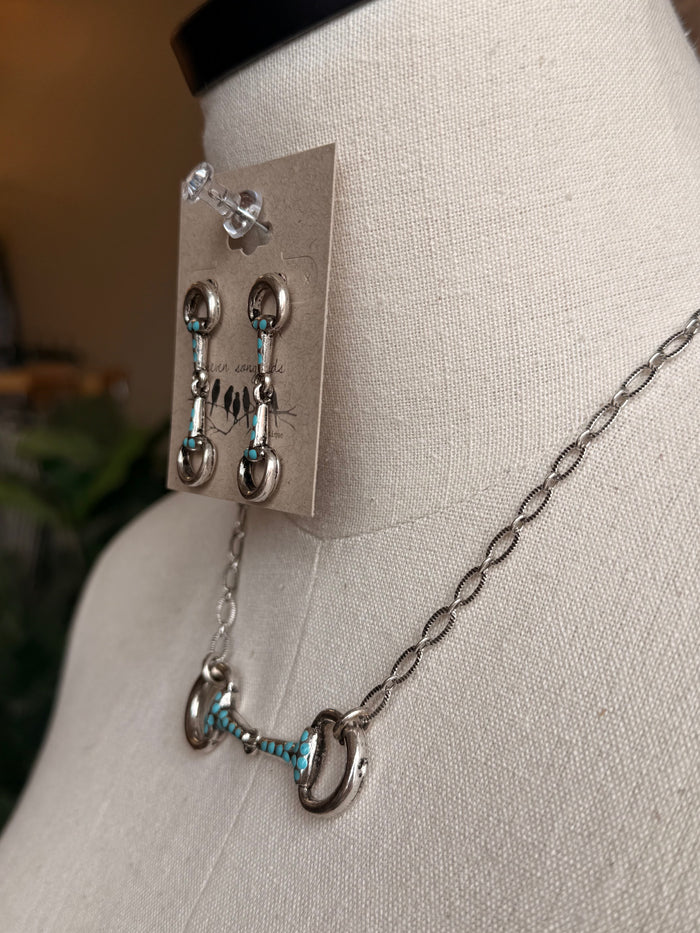 Snaffle bit earrings with turquoise accents and silver chain necklace, close-up