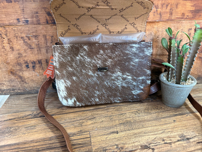 Mini flap crossbody purse with cowhide hair-on flap, metal buckle, and long crossbody strap