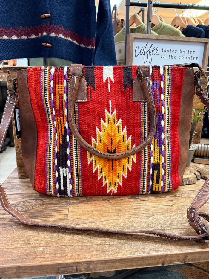 Red woven tote with multicolor geometric pattern and dark leather handles