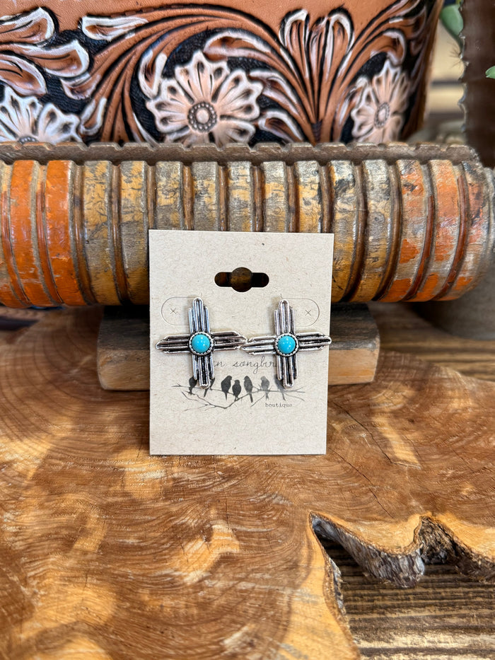 Zia symbol stud earrings with turquoise stones and cactus detailing on display card