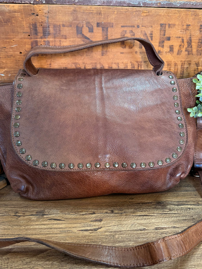 Chocolate leather flap crossbody purse front with metal stud trim and curved handle