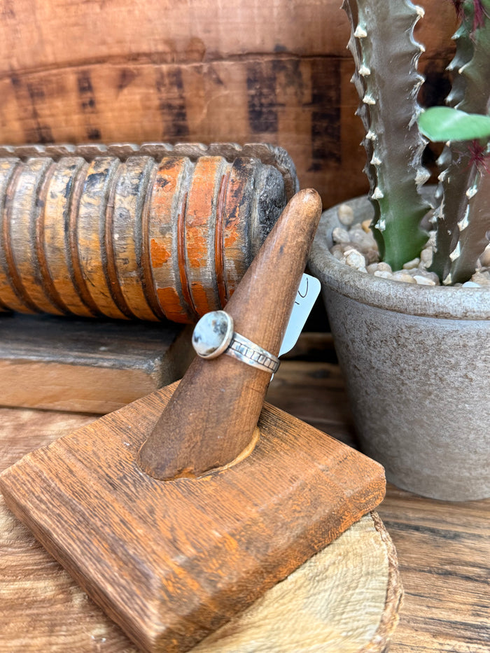 Sterling silver ring with round light blue stone and narrow textured band
