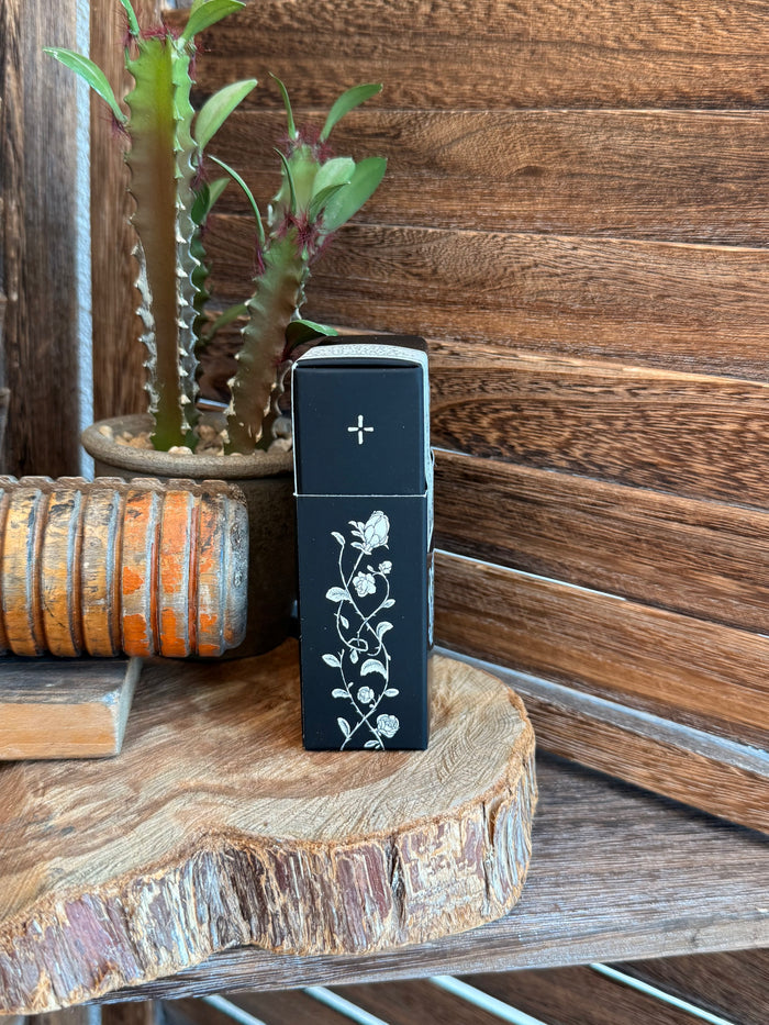 Dark blue perfume box side with white floral vine design and small cross