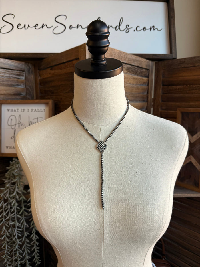 Lariat necklace with checkered spade pendant and long bead chain, dark silver tone