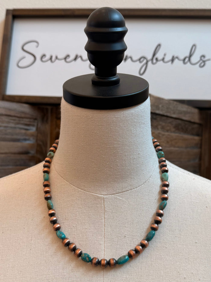 Copper and turquoise bead necklace with evenly spaced beads on mannequin bust