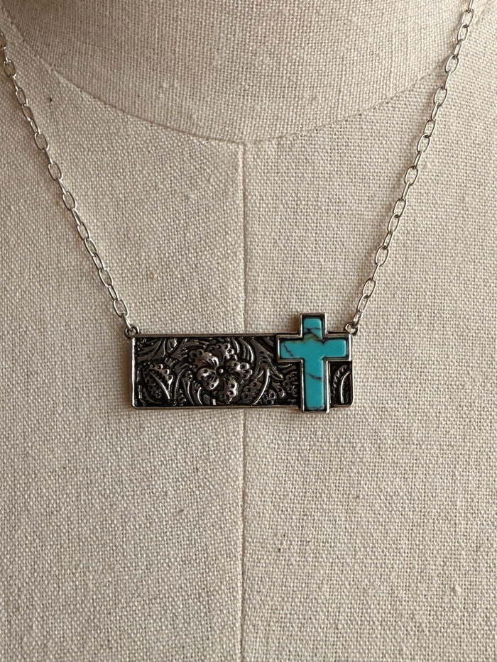 Close-up turquoise cross bar pendant necklace on silver chain