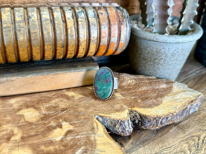 Oval turquoise natural stone adjustable ring with silver-tone bezel and rope edge.