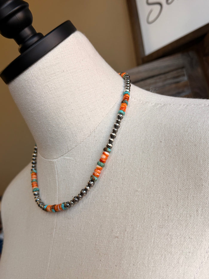 Side view turquoise and orange bead necklace on mannequin, dark metal bead chain