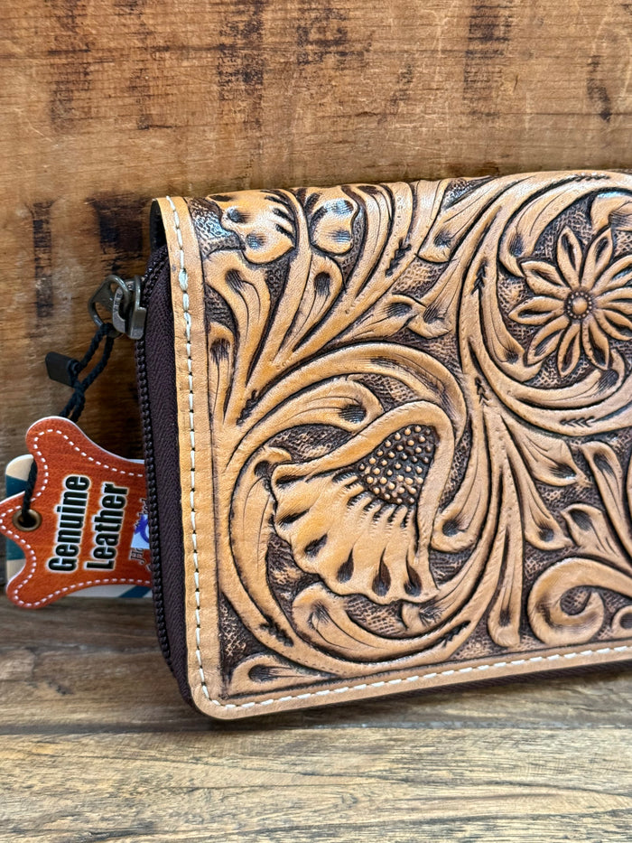 Tooled leather zip-around wallet close-up with dark floral tooling and animal motif