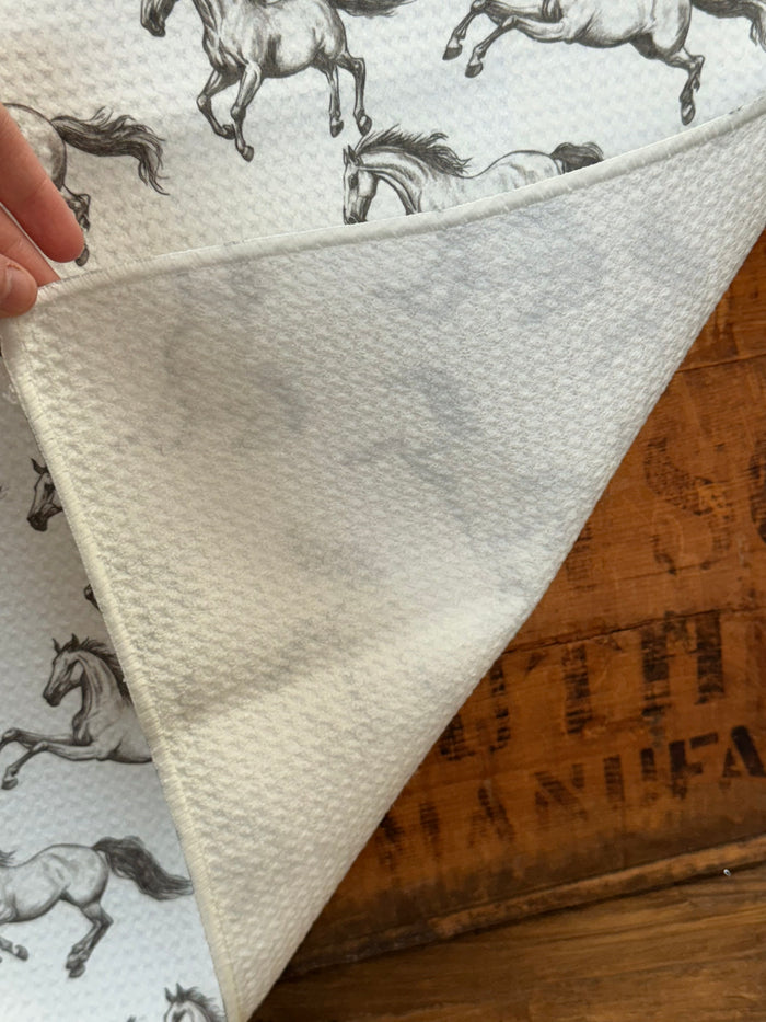 Folded horse print towel corner showing white waffle texture