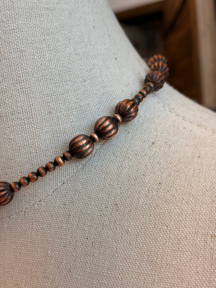 Close-up of copper pumpkin beads and spacer beads on beaded necklace