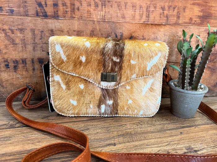 Speckled cowhide flap crossbody purse with brown leather strap and buckle closure