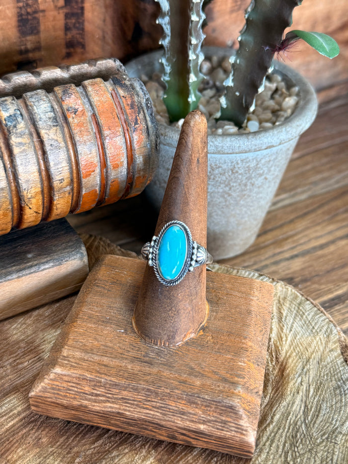 Turquoise oval cabochon sterling silver ring with serrated bezel setting