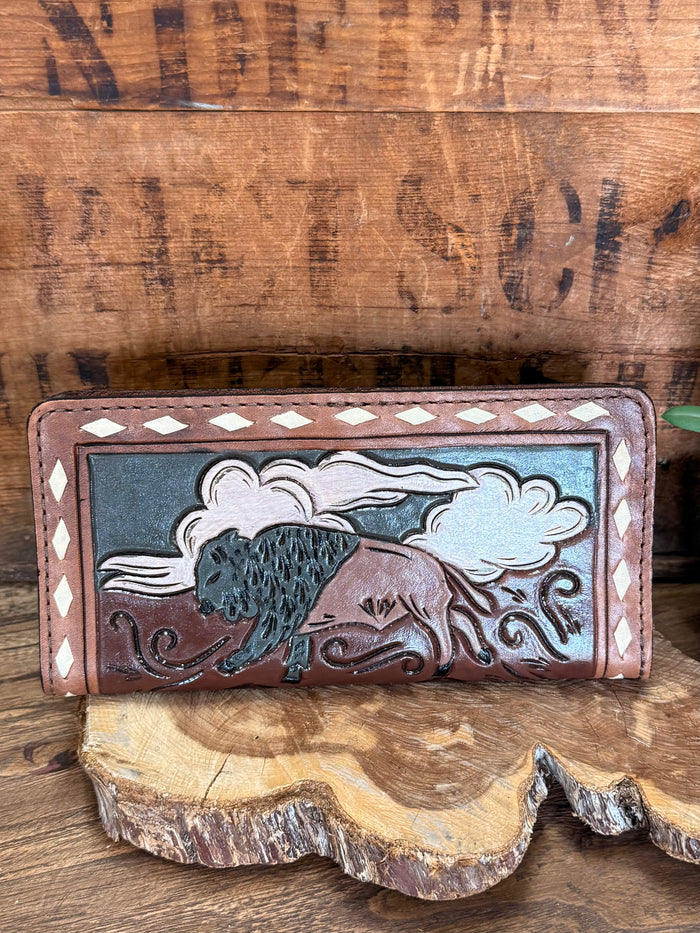 Hand-tooled leather checkbook wallet showing buffalo and cloud tooling on front panel