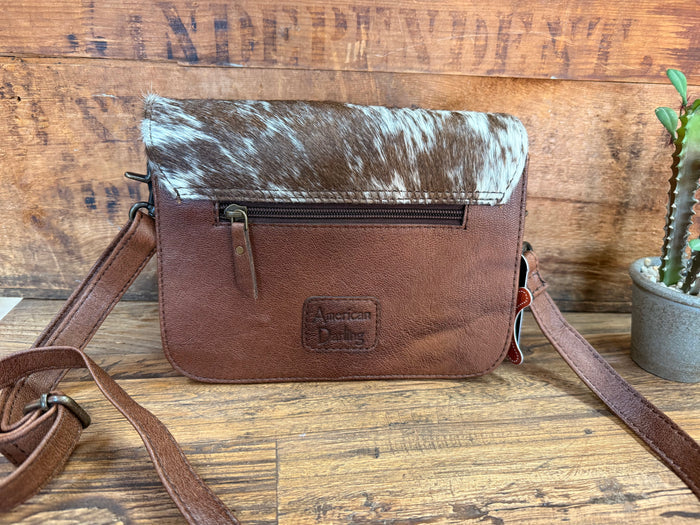 Mini crossbody purse with brown leather body, cowhide top flap, and adjustable shoulder strap