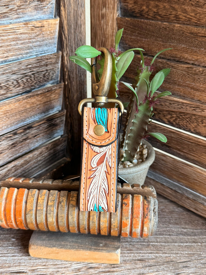 Tooled leather keychain with turquoise accents, hanging feather charm on brass ring