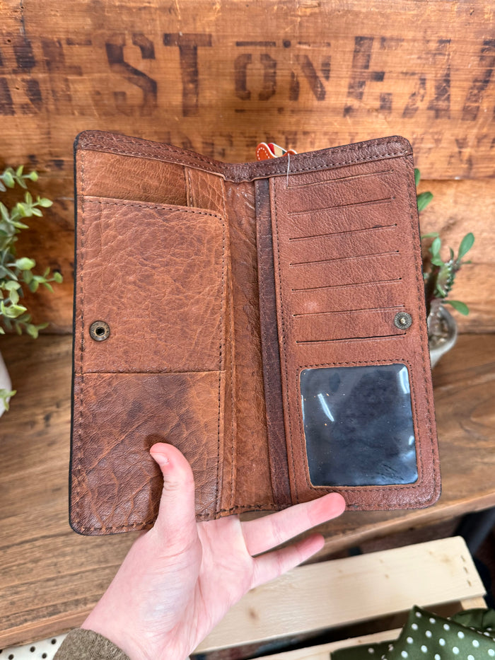 Brown leather bifold wallet interior with card slots and pen-style stitched compartments