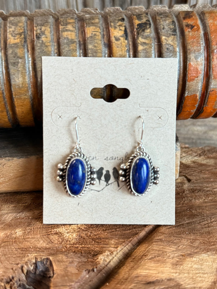 Sterling silver fishhook earrings with blue oval lapis and beaded settings on display card.