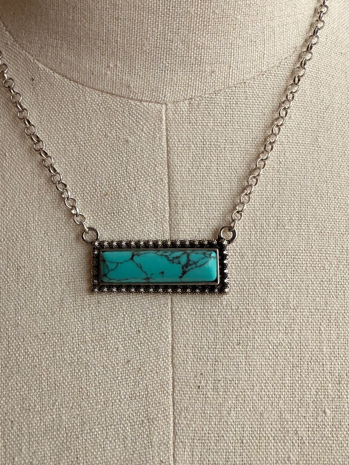 Rectangular turquoise bar pendant with black-edge bezel and silver chain